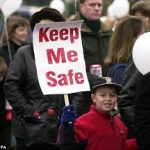 boy_wearing red jacket_sign_Keep Me Safe_hopeful